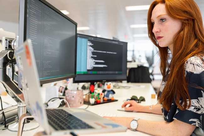 A person sitting at their desk at work, programming