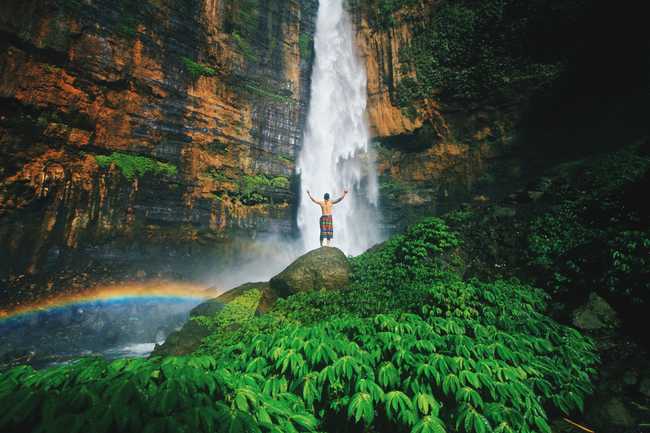 Jumping into a lake with a waterfall