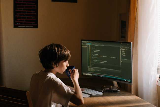 A child at a computer coding an application